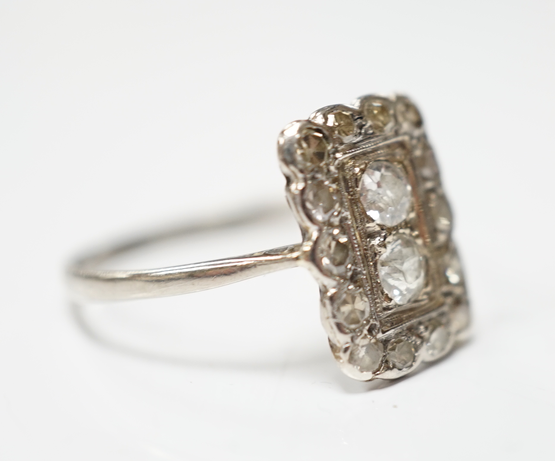 An early 20th century white metal and diamond cluster set tablet ring, size P/Q, gross weight 2.2 grams.